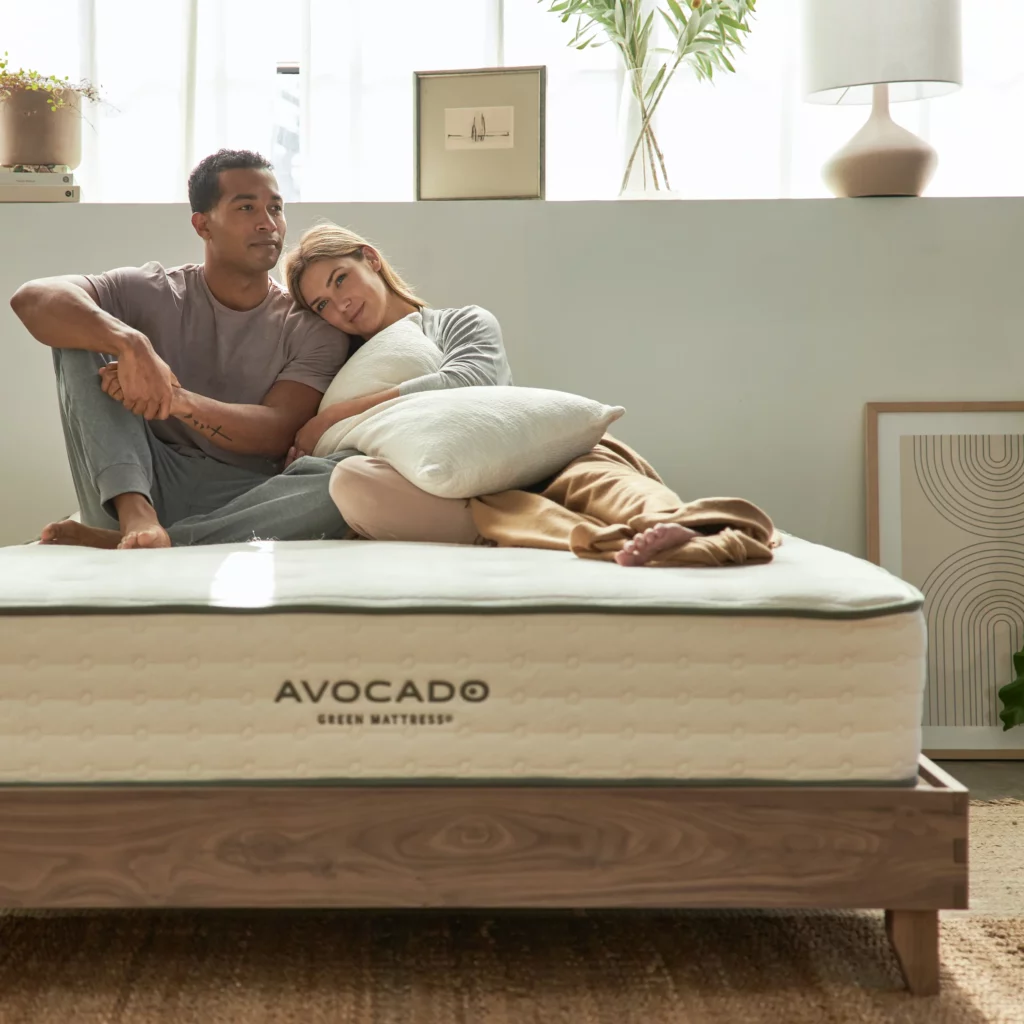 man-and-woman-sitting-on-handcrafted-wood-bed-set