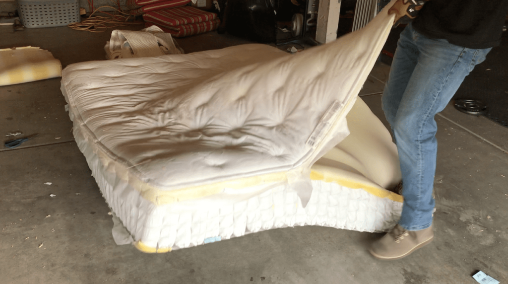 man-tearing-open-an-old-mattress